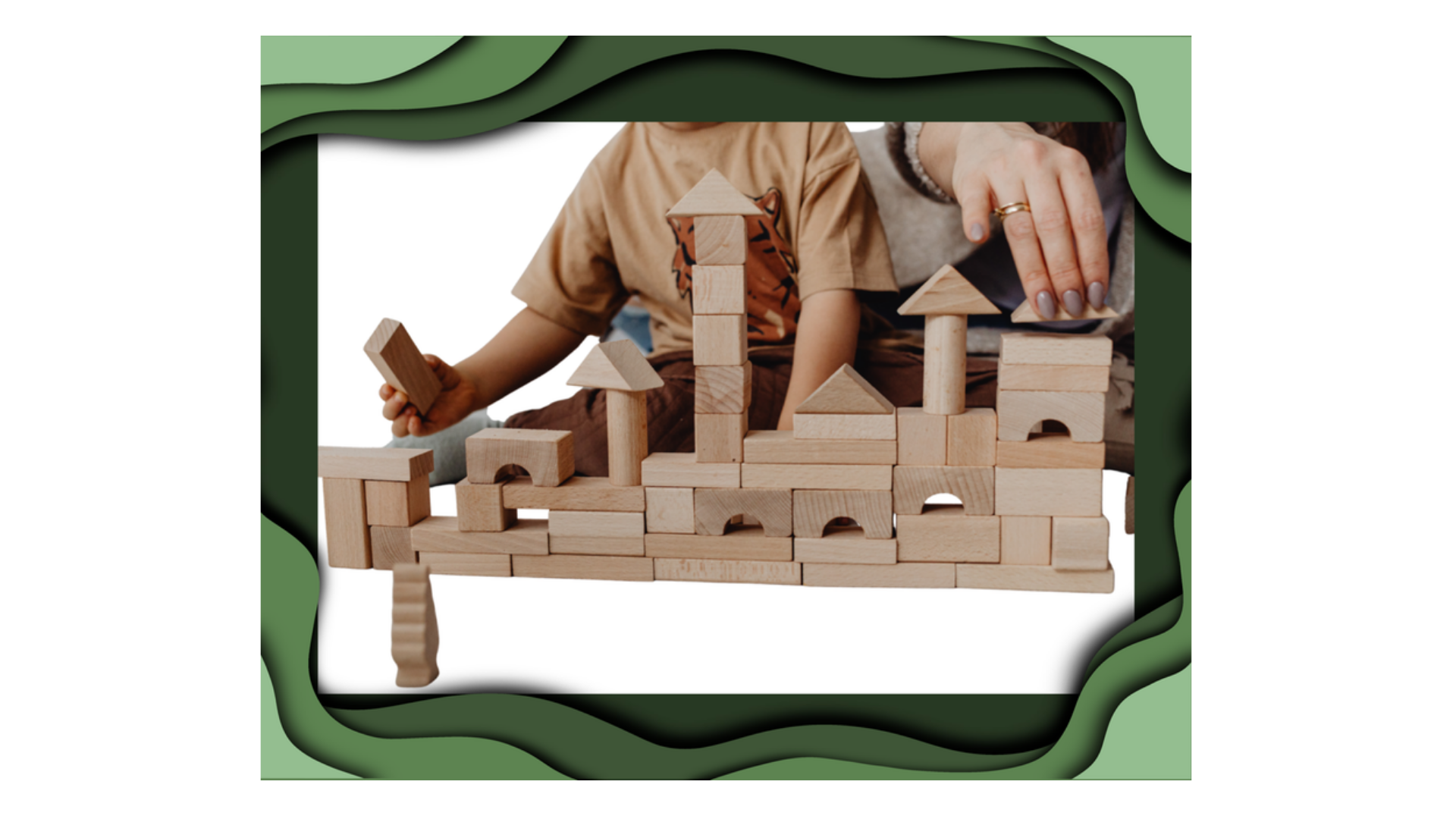 A child and a parent building a row of towers and arches from plain wooden blocks, inside a green painted frame