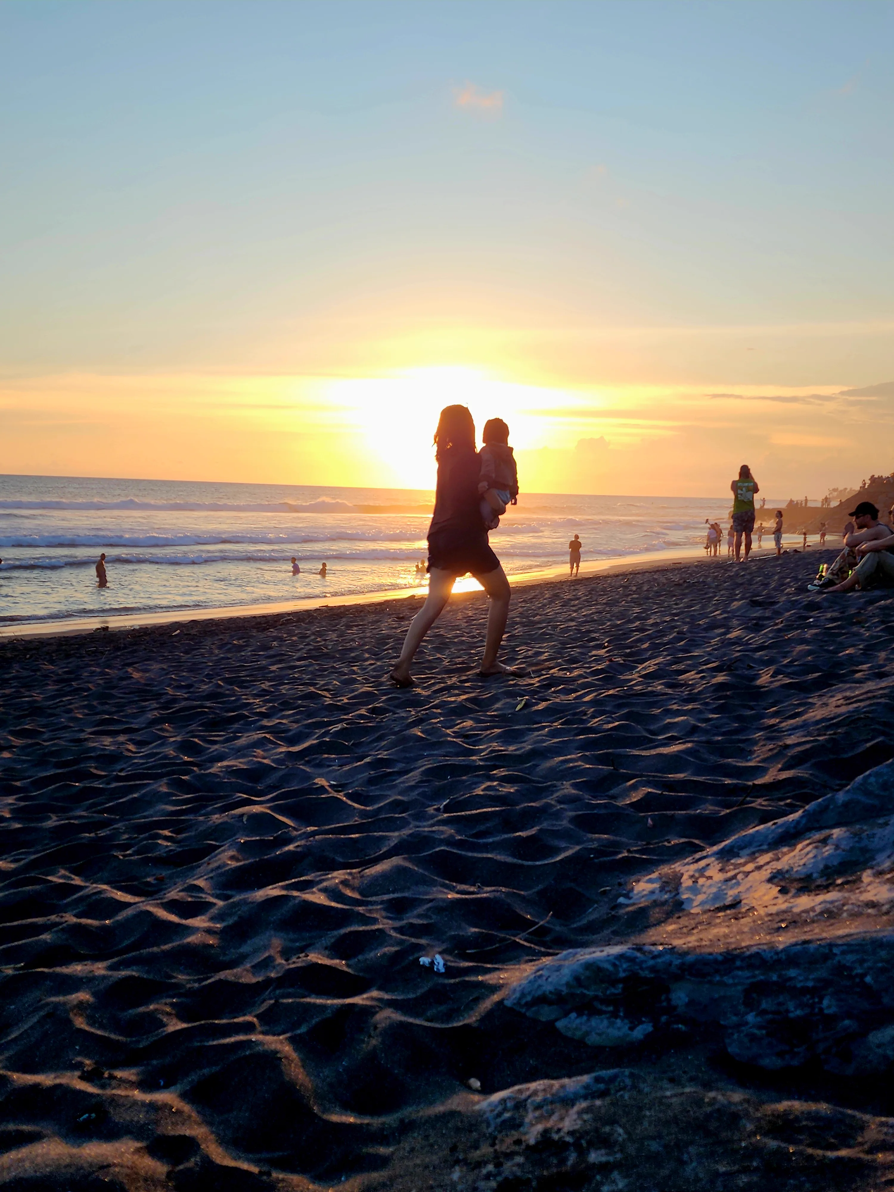 Parent and child together at the beach at sunset